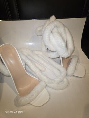 White Stiletto 4" heels feature a pointed toe and wrapping faux fur strap
